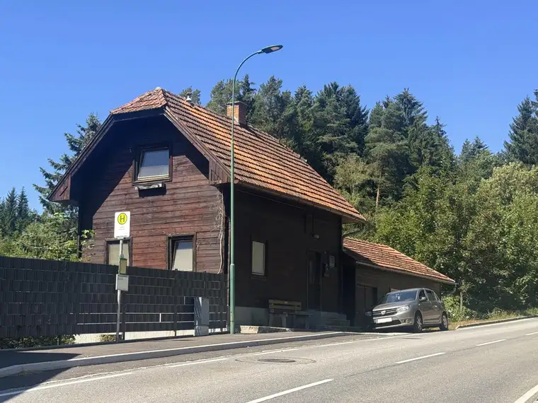 Charmantes Holzblockhaus in grüner Umgebung mit Nebengebäude