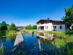 Exklusivität und Privatsphäre pur auf 2.610 m2 Grundfläche! Von der Terrasse in den Schwimmteich.