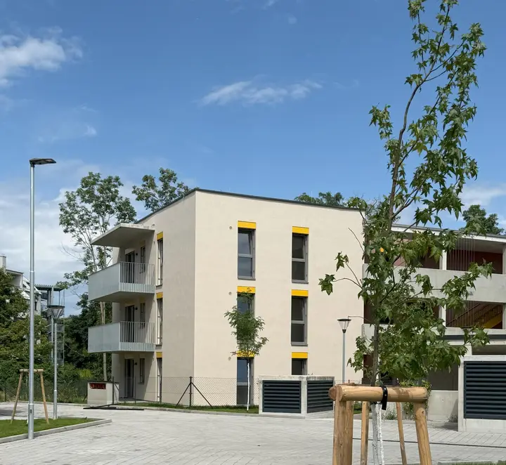 Wohnhaus mit Balkonen und Bäumen