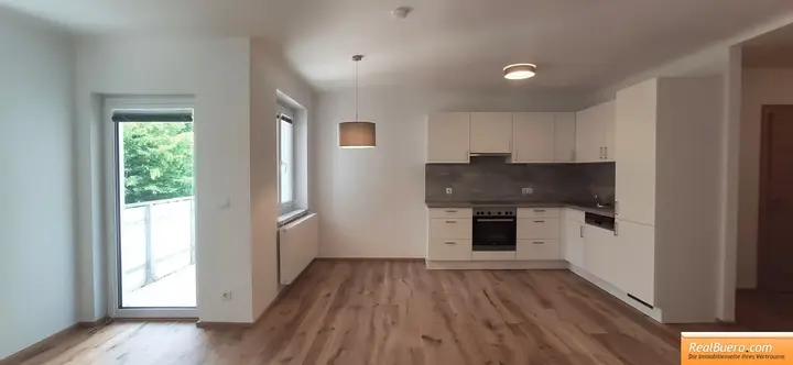 Wohnesszimmer mit Einbauküche und Ausgang zum Balkon