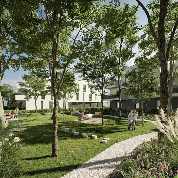 Blick auf den Gemeinschaftsfreibereich in Leopoldsdorf mit einer Familie, Spielplatz, Kiesweg und modernen Wohngebäuden im Hintergrund (Wiesen, Bäumen).