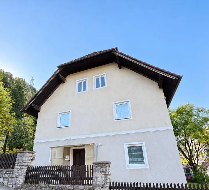 Helles Alpenhaus unter blauem Himmel