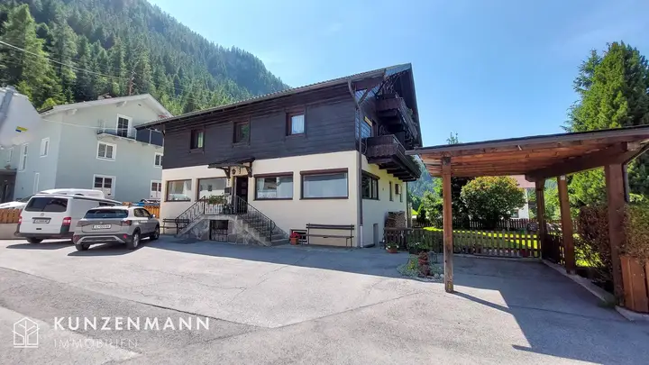 Ostansicht mit Parkplätzen und Carport