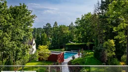 Großzügiger Gartenbereich mit Swimmingpool, umgeben von altem Baumbestand und viel Grün.