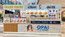 Ein moderner Frozen Yogurt und Gyros Stand in einem Einkaufszentrum mit Marmor- und Holzdetails.