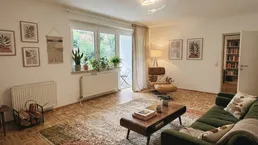 Helles Wohnzimmer mit Parkettboden, moderner Dekoration und Zugang zu einer Terrasse.