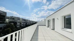 Geräumige Dachterrasse mit weitem Blick auf die umliegenden Gebäude und viel Sonnenlicht.