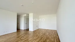 Helles, leeres Zimmer mit Parkettboden und weißen Wänden, bereit zur individuellen Gestaltung.