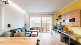 Helles Wohn- und Esszimmer mit Holzboden, moderner Einrichtung und Zugang zur Terrasse.