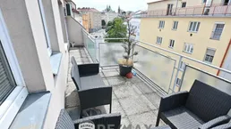 Geräumige Terrasse mit Sitzgelegenheiten und Blick auf die umliegende Stadtlandschaft.