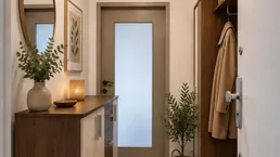 Modern eingerichteter Flur mit Garderobe, Spiegel und Ablagefläche für einen einladenden Eingangsbereich.