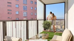 Möblierter Balkon mit Kunstrasen und weitem Blick über die Stadt, ideal zum Entspannen.