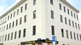 Eckgebäude mit klassischer Architektur und Gewerbefläche im Erdgeschoss in urbaner Umgebung.
