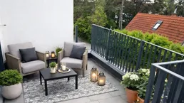 Gemütlicher Balkon mit Outdoor-Sitzgelegenheiten und Blick ins Grüne.