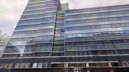 Modernes Hochhaus mit beeindruckender Glasfassade und vielen Fenstern, das eine zeitgenössische Architektur aufweist.