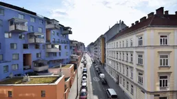 Blick auf eine belebte Stadtstraße mit verschiedenen Wohngebäuden und parkenden Autos.