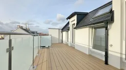 Geräumige Dachterrasse mit Holzboden und Glasgeländer, ideal für Entspannung im Freien.