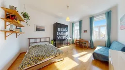 Helles Zimmer mit Bett, Sofa, Esstisch und Holzfußboden, ideal für ein Studio-Apartment.