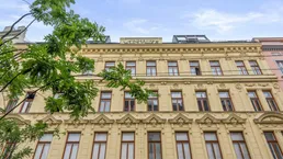 Historische Fassade eines Altbaus mit vielen Fenstern und dekorativen Elementen.