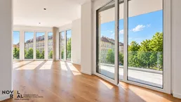 Helles Wohnzimmer mit großen Fenstern, Holzboden und Zugang zum Balkon mit Stadtblick.