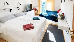 Helles Schlafzimmer mit zwei Betten, Klimaanlage und Zugang zum Balkon.