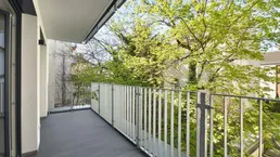 Geräumiger Balkon mit modernem Geländer und Blick ins Grüne, ideal für entspannte Stunden im Freien.