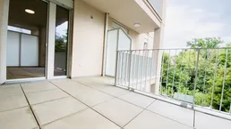 Geräumiger Balkon mit Fliesenboden und Blick ins Grüne, ideal für entspannte Stunden im Freien.