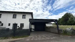 Ansicht des modernen Reihenhauses mit integriertem Carport und Zufahrt.