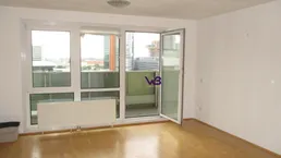 Helles Wohnzimmer mit Parkettboden und Zugang zu einem Balkon mit Stadtblick.