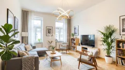 Helles Wohnzimmer mit modernem Design, Parkettboden und großen Fenstern, ausgestattet mit stilvollen Möbeln.