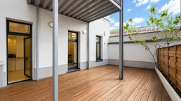 Geräumige Terrasse mit Holzboden und Zugang zu den Innenräumen, ideal für entspannte Stunden im Freien.