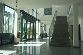 Modernes Bürohaus mit viel Glas und zahlreichen Autostellplätzen an Wiener Stadtgrenze