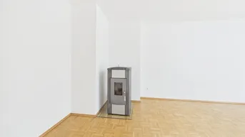 Helles Wohnzimmer mit Parkettboden und einem modernen Holzofen für gemütliche Wärme.