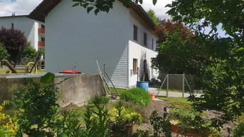 Seitenansicht des Hauses mit angrenzendem Gartenbereich und verschiedenen Pflanzen.