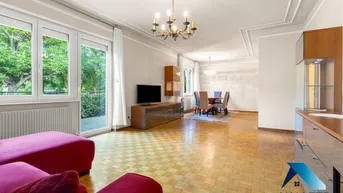 Geräumiger Wohn-Essbereich mit Parkettboden, Stuckdecke und Zugang zum Balkon.