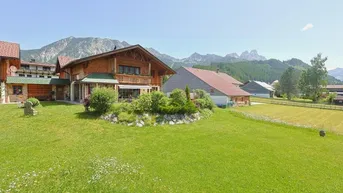 Großzügiges Anwesen mit traditionellem Holzhaus, weitläufigem Garten und beeindruckendem Bergblick.