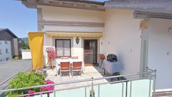 Geräumige Terrasse mit Essbereich, Grill und Blick auf die umliegende Landschaft, ideal für entspannte Stunden im Freien.