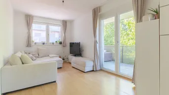 Helles Wohnzimmer mit hellem Parkettboden, Sofa und direktem Zugang zu einem Balkon.