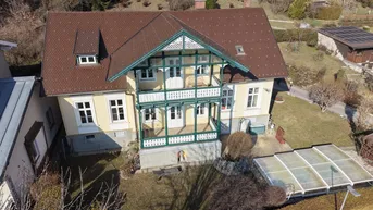 Historisches Haus mit traditioneller Fassade, Balkonen und Gartenbereich.