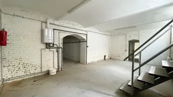 Geräumiger Kellerraum mit weiß gestrichenen Ziegelwänden, Betonboden und sichtbarer Heizungsanlage.