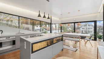 Moderne offene Küche mit Essbereich, Kochinsel und großen Fenstern mit Ausblick.