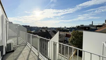 Sonnige Dachterrasse mit weitem Stadtblick, Fliesenboden und Klimaanlage.