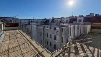 Geräumige Dachterrasse mit Blick auf umliegende Gebäude und viel Sonnenlicht.