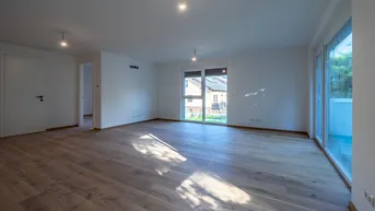 Heller Wohnraum mit Holzboden und Blick auf die Nachbarschaft.