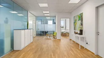 Moderner Bürobereich mit Glaswänden, Holzfußboden und hellem Empfangsbereich, ideal für Unternehmen.