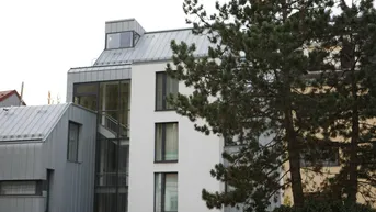 Moderne Architektur eines Wohngebäudes mit Metallfassade und großen Fenstern.