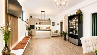 Moderner offener Wohnbereich mit integrierter Küche, Essplatz und gemütlicher Sofaecke.