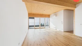 Helles, geräumiges Zimmer mit Holzbalkendecke, Parkettboden und Zugang zu einer Terrasse mit Weitblick.