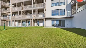 Moderne Wohnanlage mit Balkonen und direktem Zugang zu einer gepflegten Rasenfläche.
