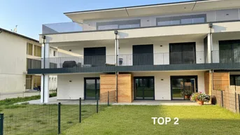 Moderne Wohnanlage mit Balkonen, Terrassen und einem gepflegten Rasenbereich im Vordergrund.